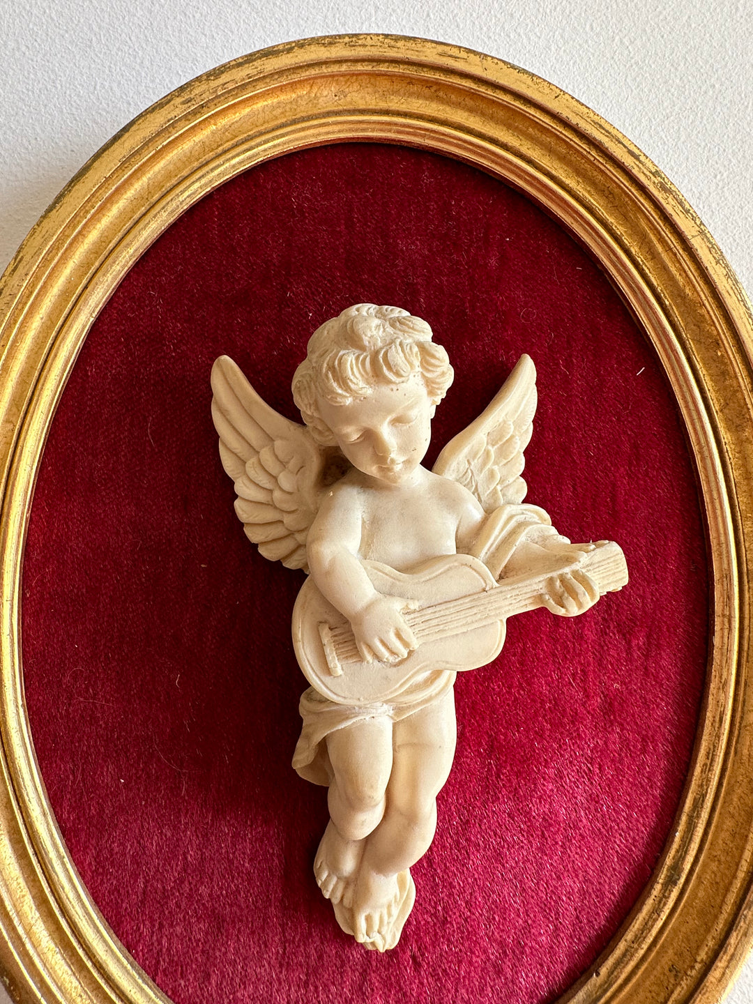 Angelot encadré de bois sur velours rouge