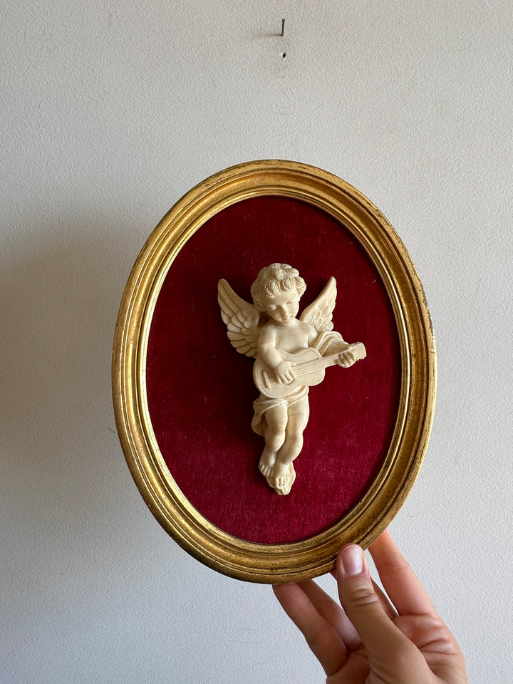 Angelot encadré de bois sur velours rouge