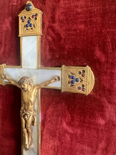 Crucifix en laiton et nacre encadré sur fond de velours rouge grenat