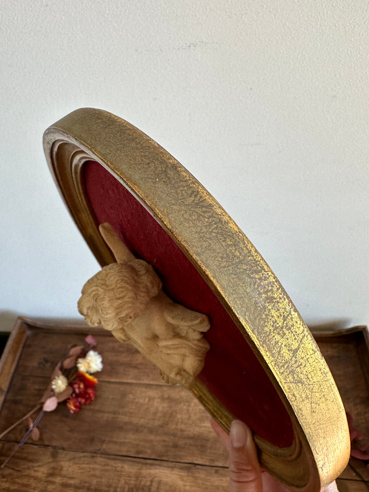 Angelot encadré de bois sur velours rouge