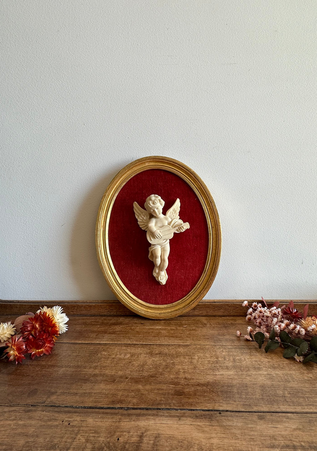 Angelot encadré de bois sur velours rouge