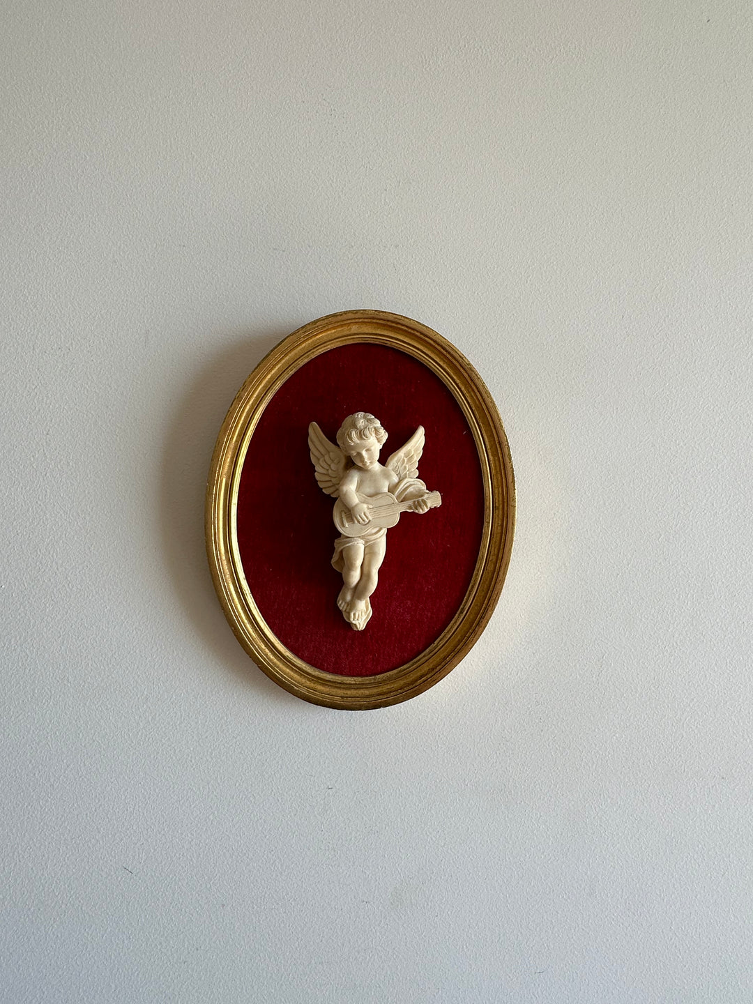Angelot encadré de bois sur velours rouge