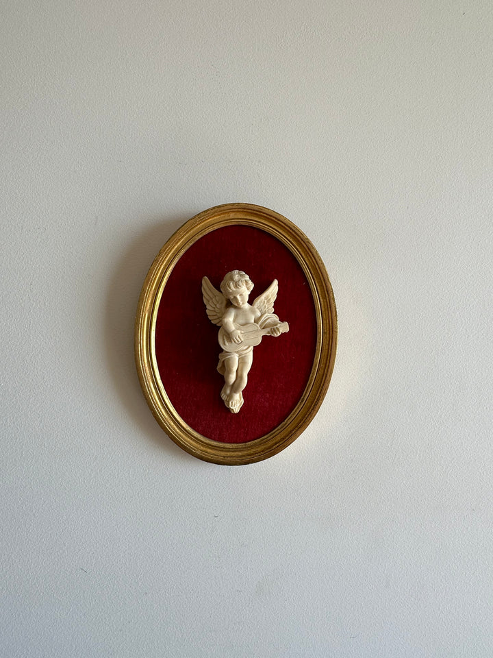Angelot encadré de bois sur velours rouge