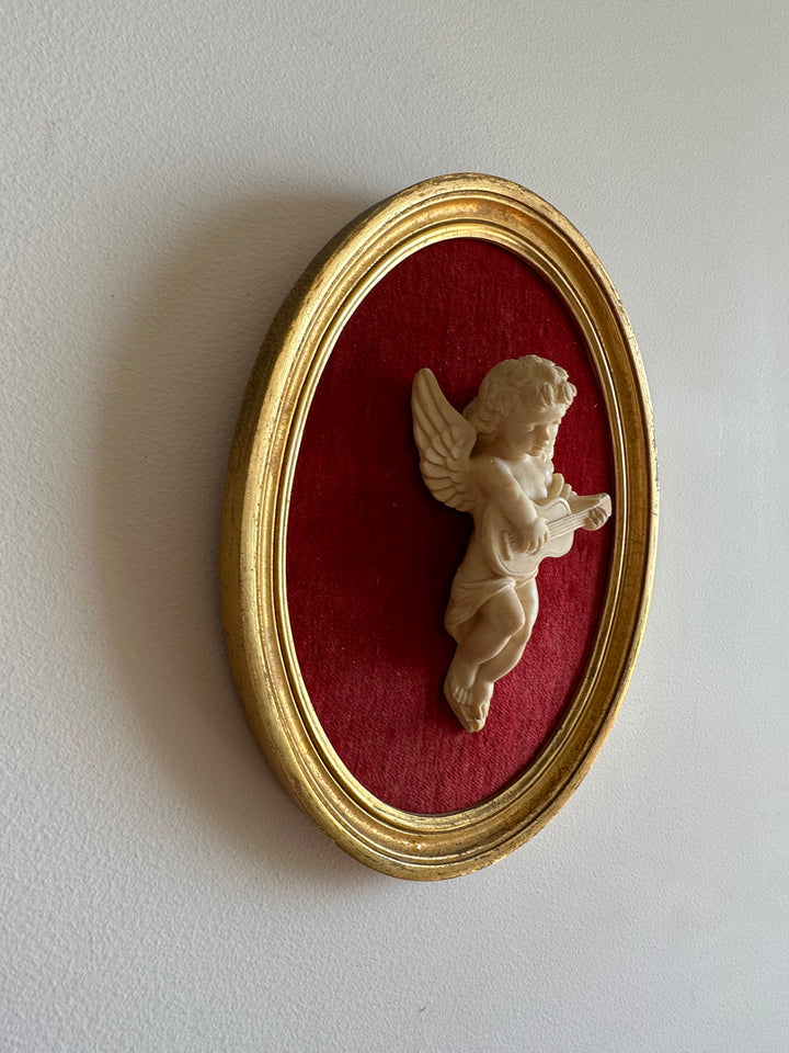 Angelot encadré de bois sur velours rouge