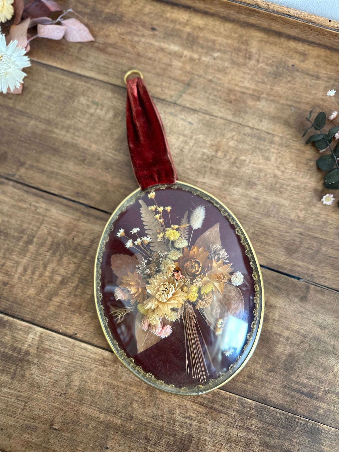 Composition florale sous verre bombé fond violine ruban bordeaux