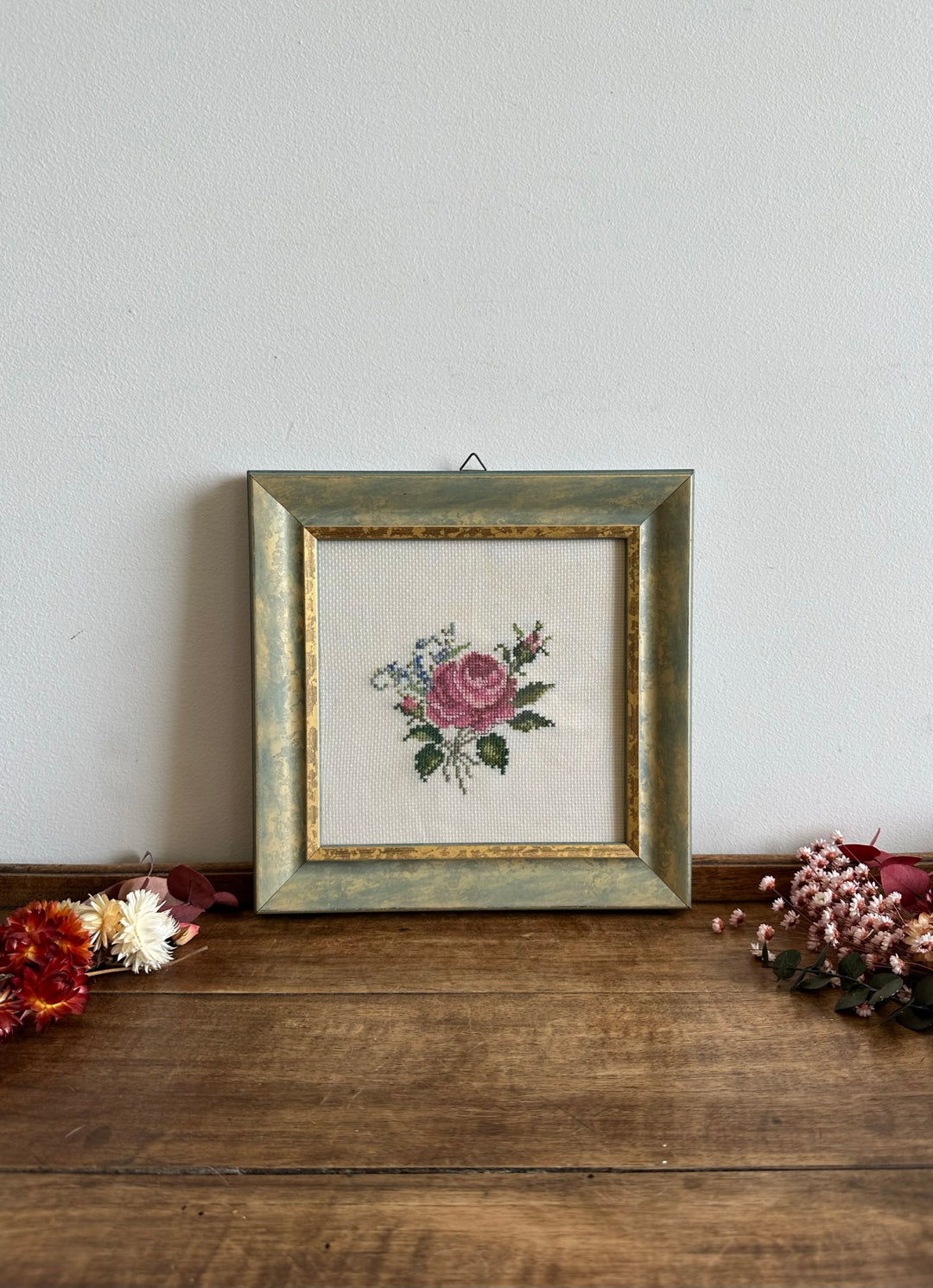 Broderie au point de croix dans cadre en bois bleu liseré doré