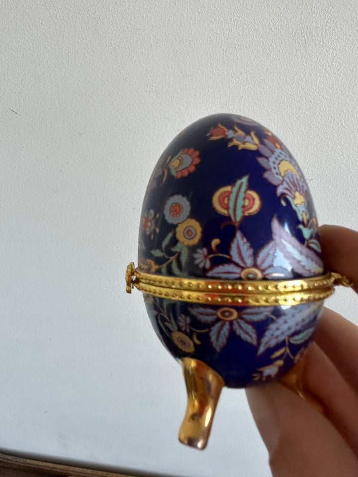 Oeuf en porcelaine sur pieds dorés