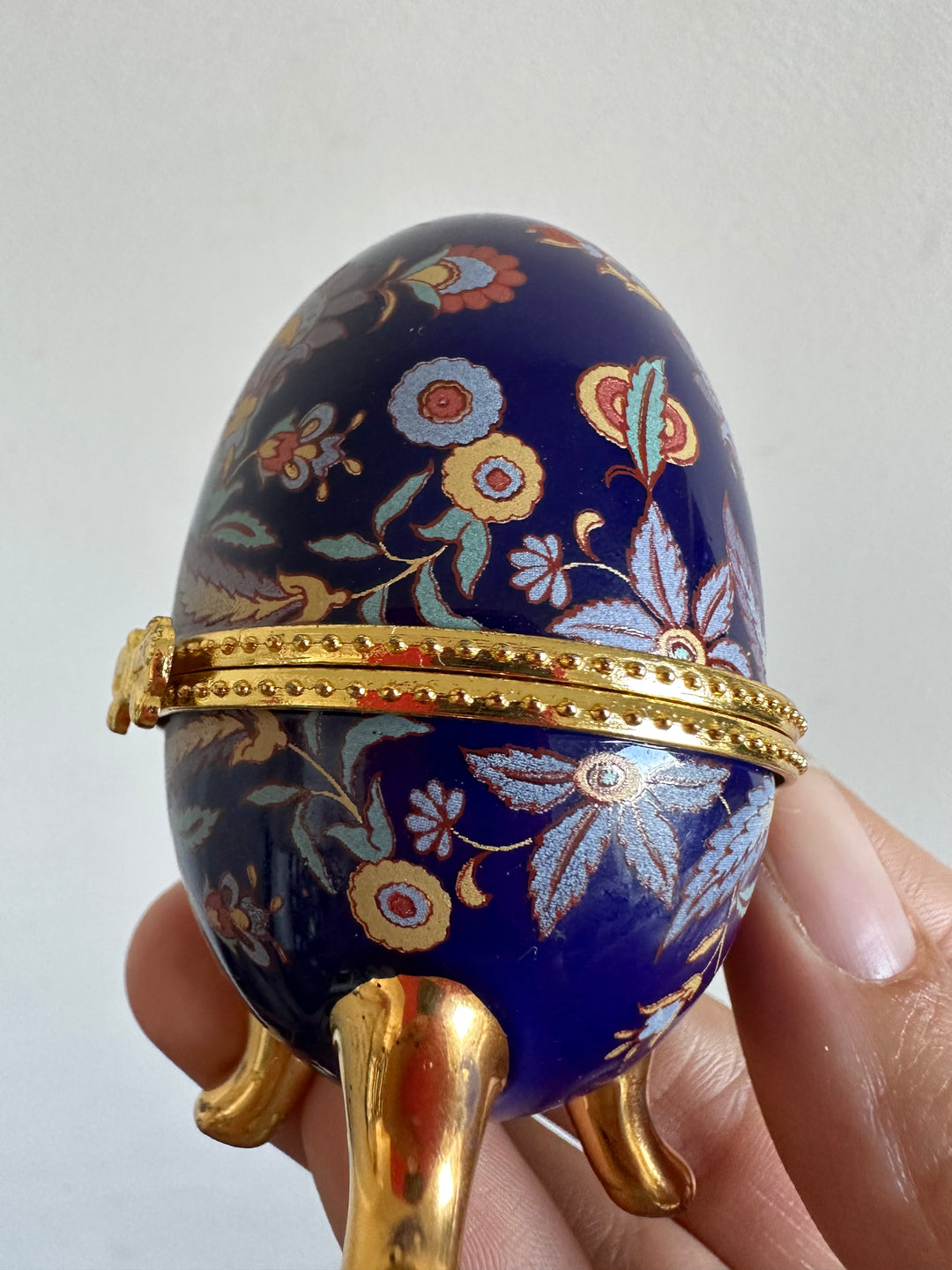 Oeuf en porcelaine sur pieds dorés