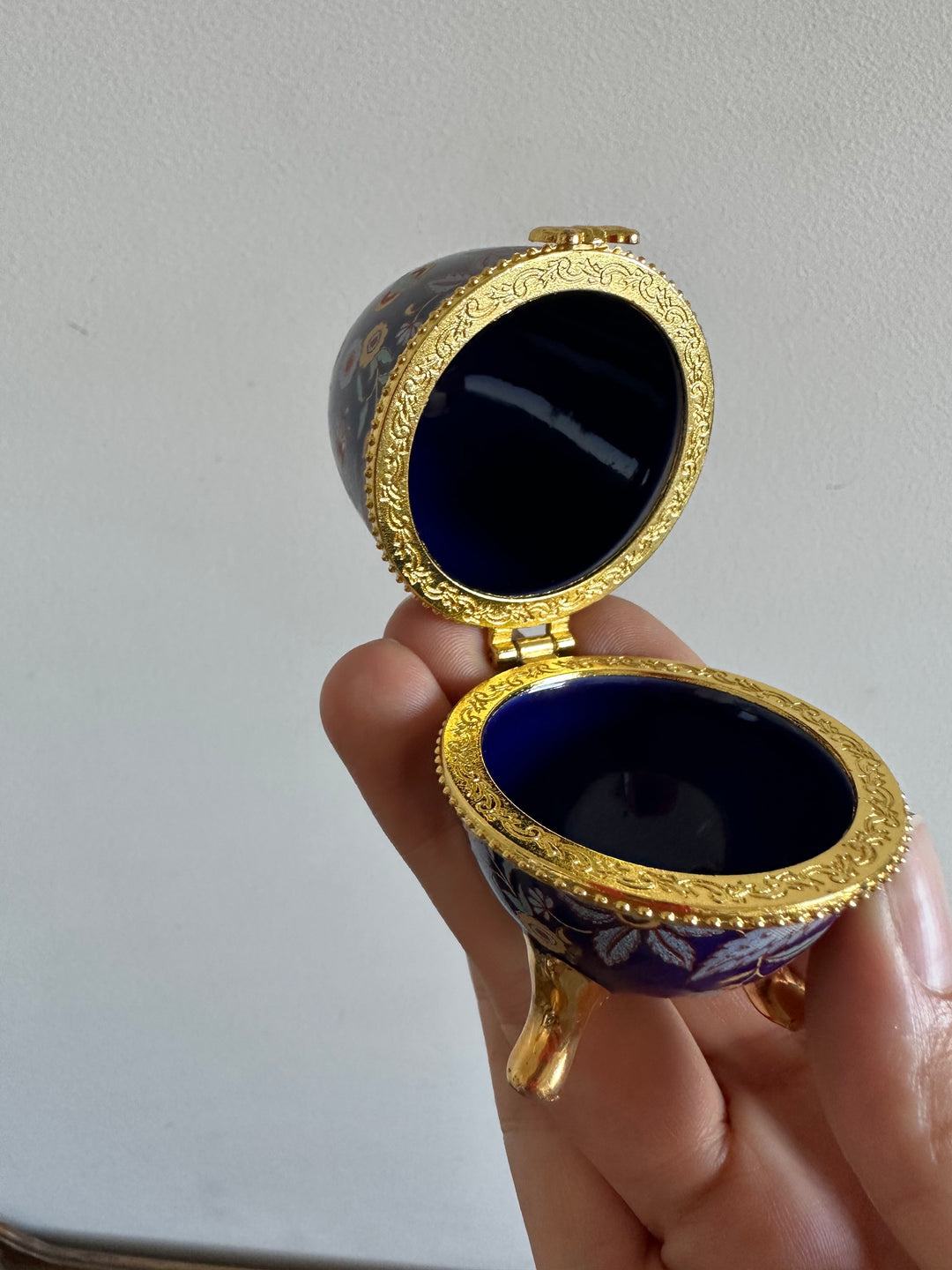 Oeuf en porcelaine sur pieds dorés