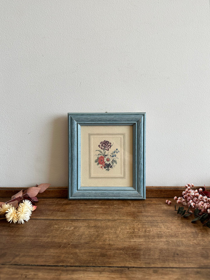 Représentation florale dans cadre en bois bleu