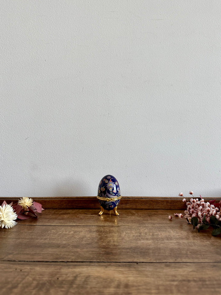 Oeuf en porcelaine sur pieds dorés