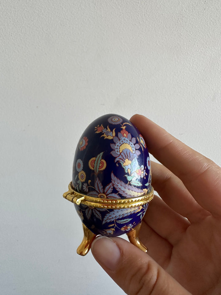 Oeuf en porcelaine sur pieds dorés