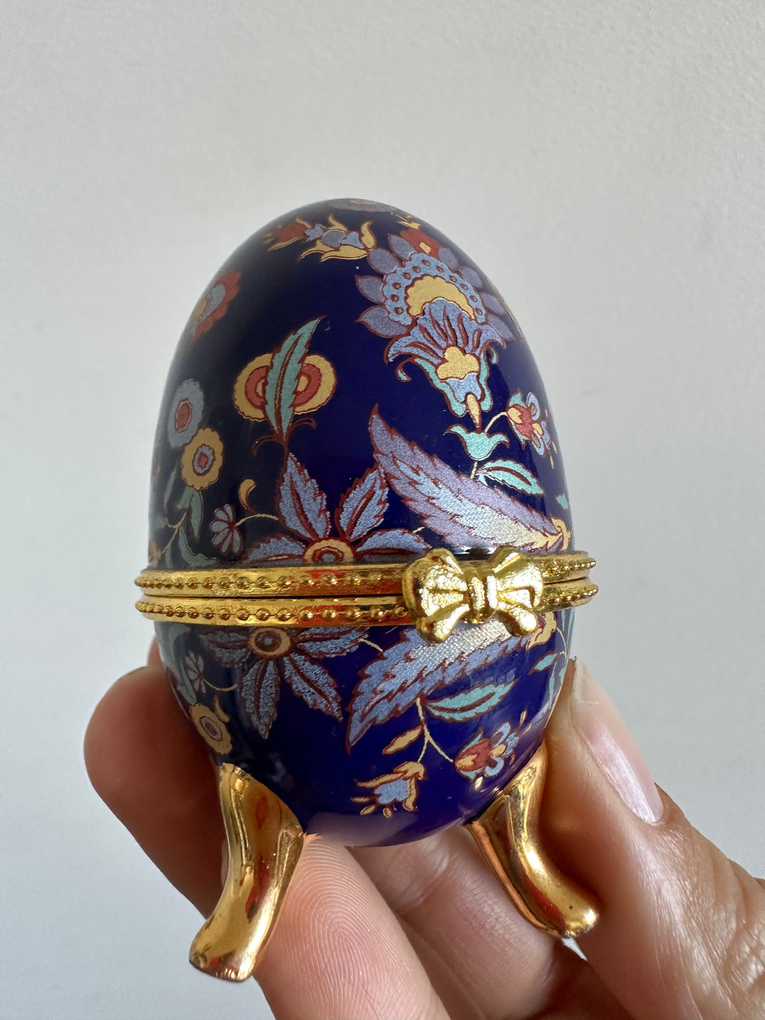 Oeuf en porcelaine sur pieds dorés