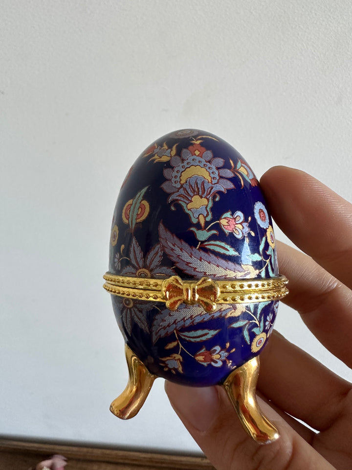 Oeuf en porcelaine sur pieds dorés