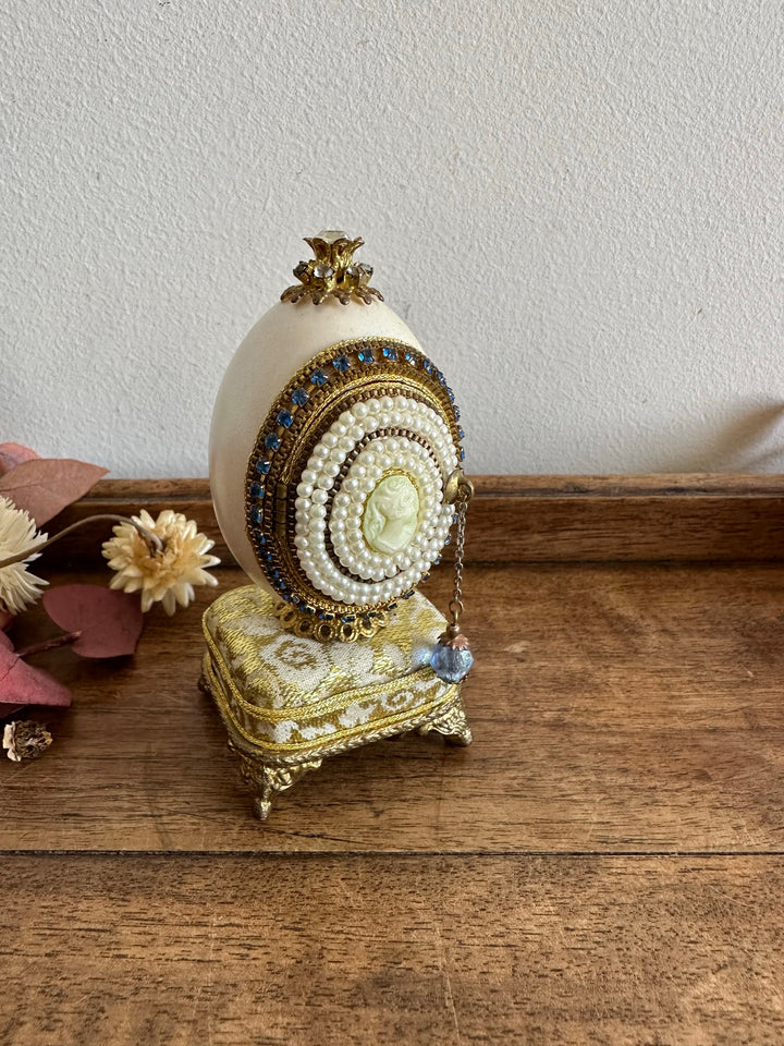 Oeuf perlé boîte à musique sur socle doré