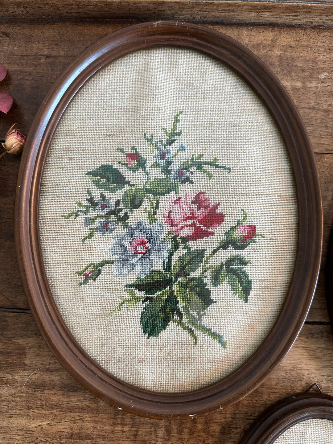 Broderies ovales anciennes encadrées sous verre