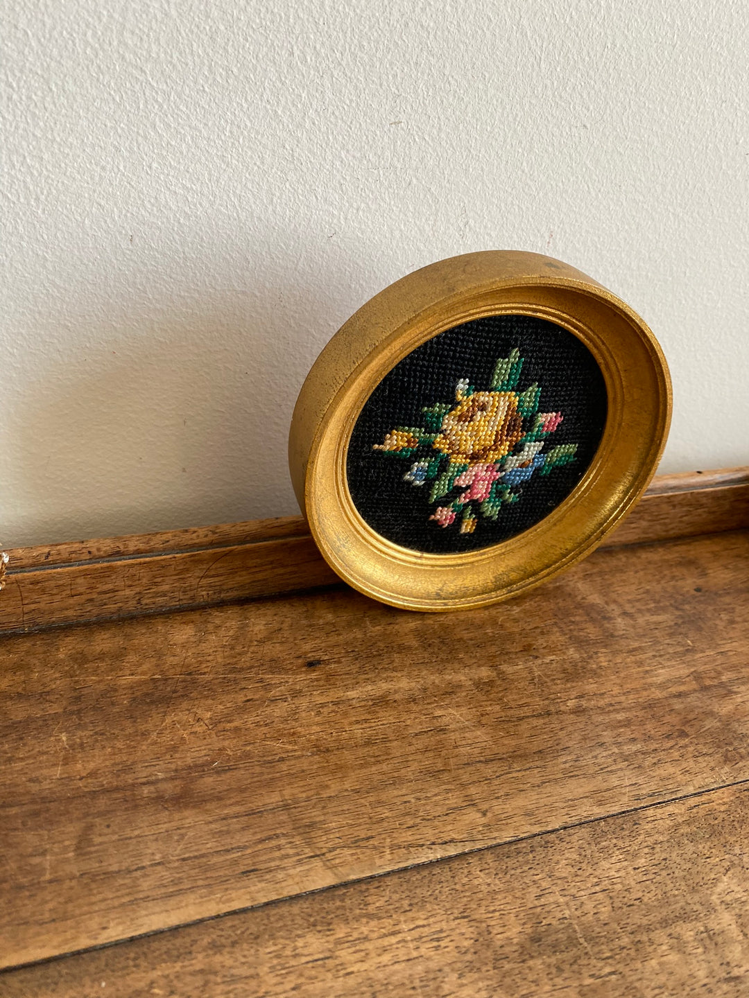 Broderie encadrée sur fond noir cadre rond doré