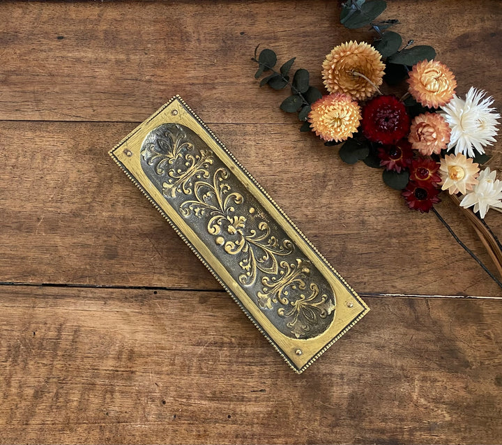 Plaque en laiton rectangulaire décorée de fleurs sculptées