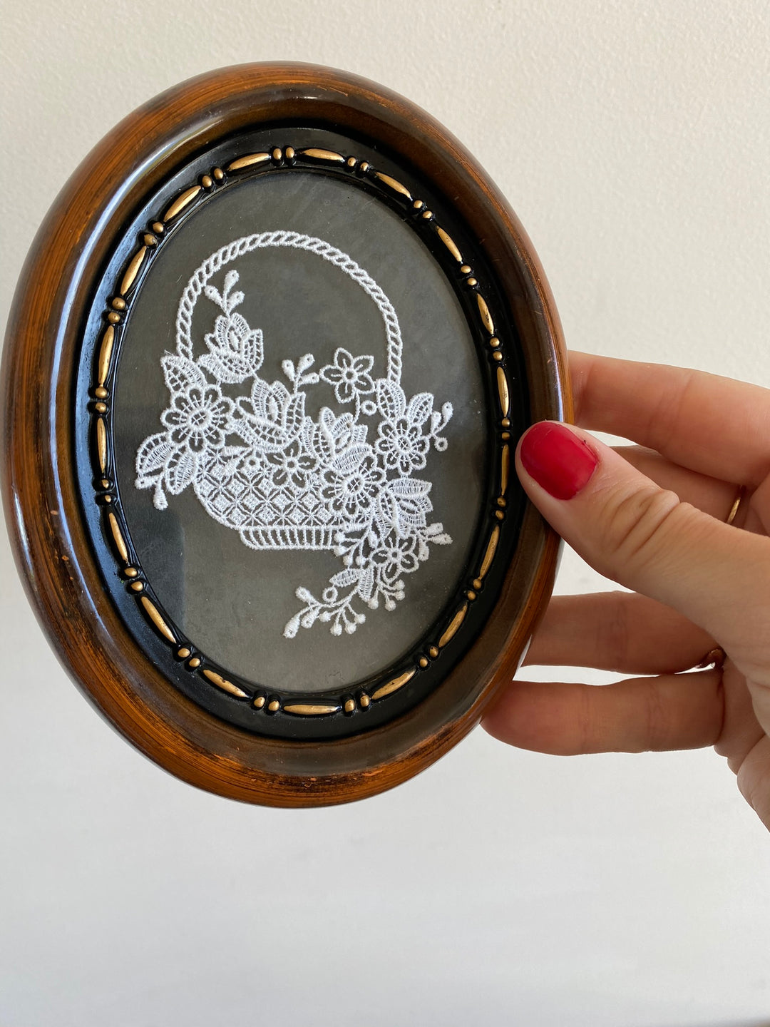 Broderie panier encadrée sur fond noir cadre marron