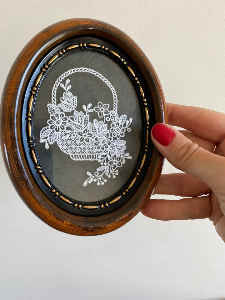 Broderie panier encadrée sur fond noir cadre marron