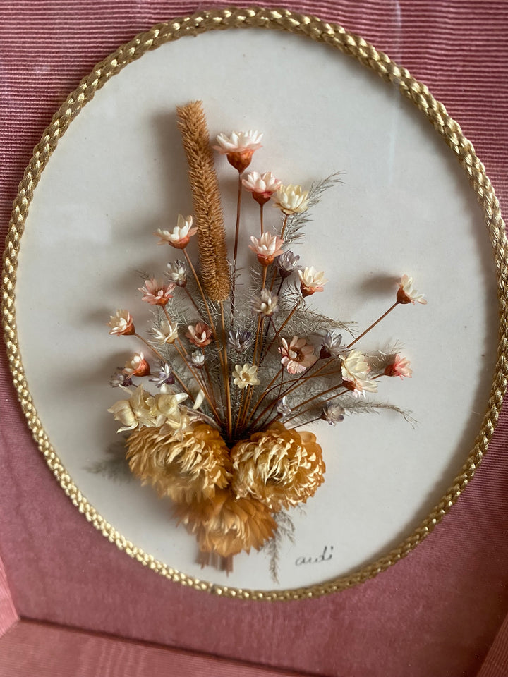 Fleurs séchées encadrées sur fond rose en tissu