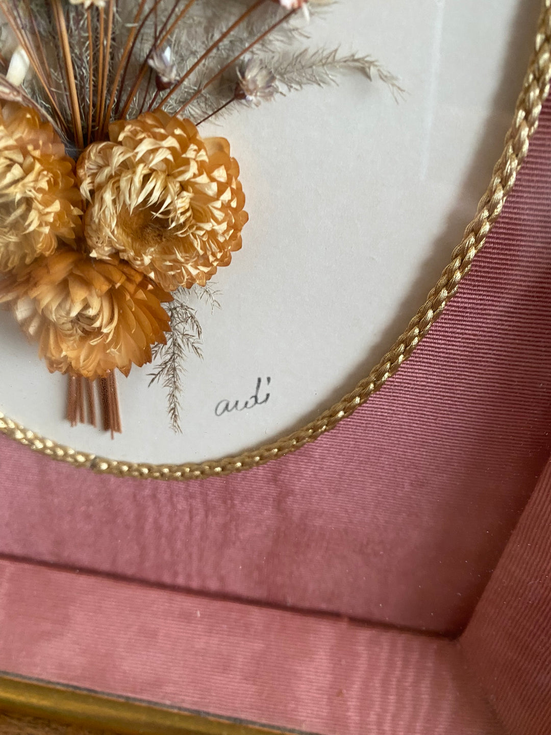 Fleurs séchées encadrées sur fond rose en tissu