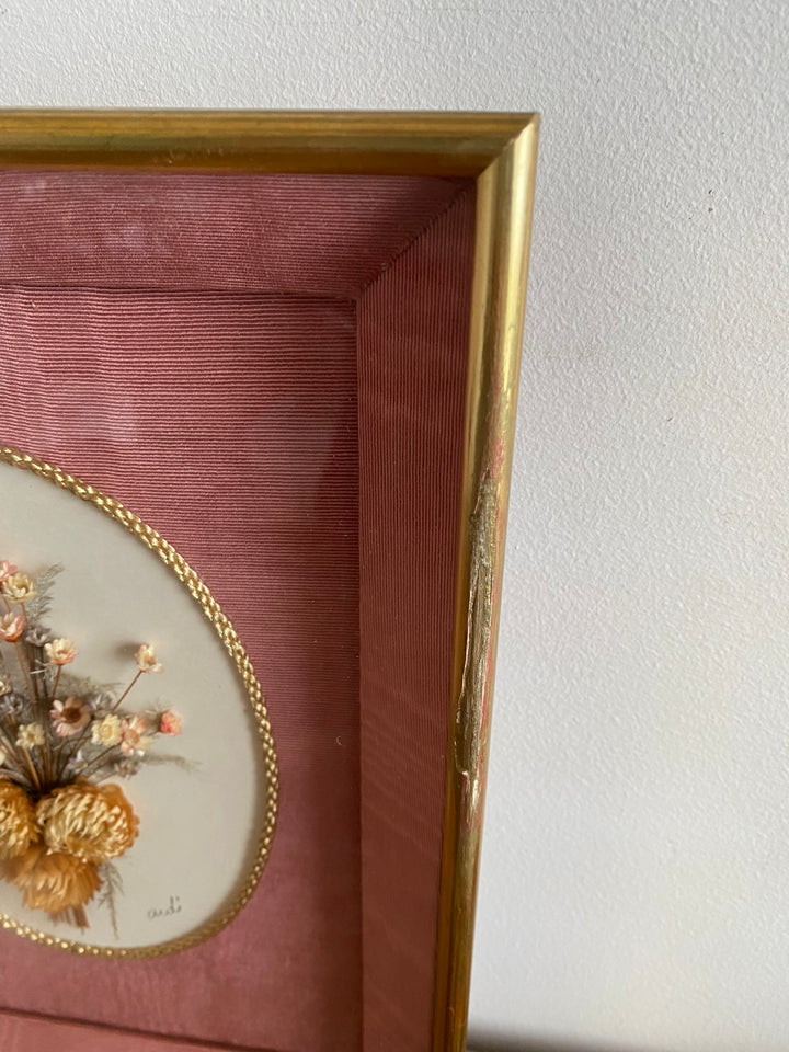 Fleurs séchées encadrées sur fond rose en tissu