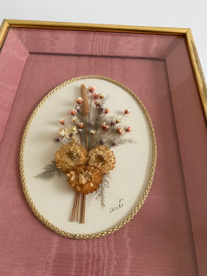 Fleurs séchées encadrées sur fond rose en tissu