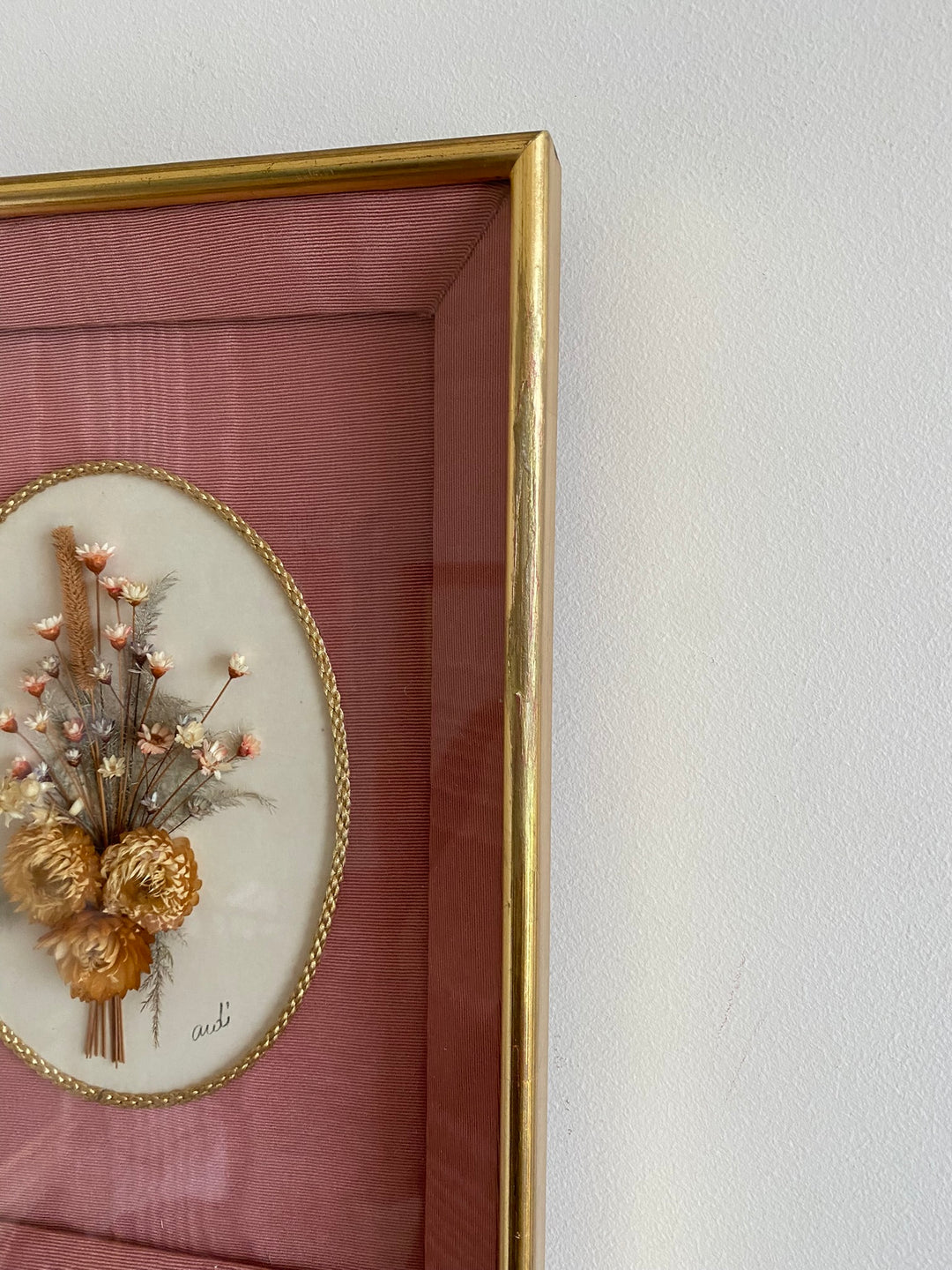 Fleurs séchées encadrées sur fond rose en tissu