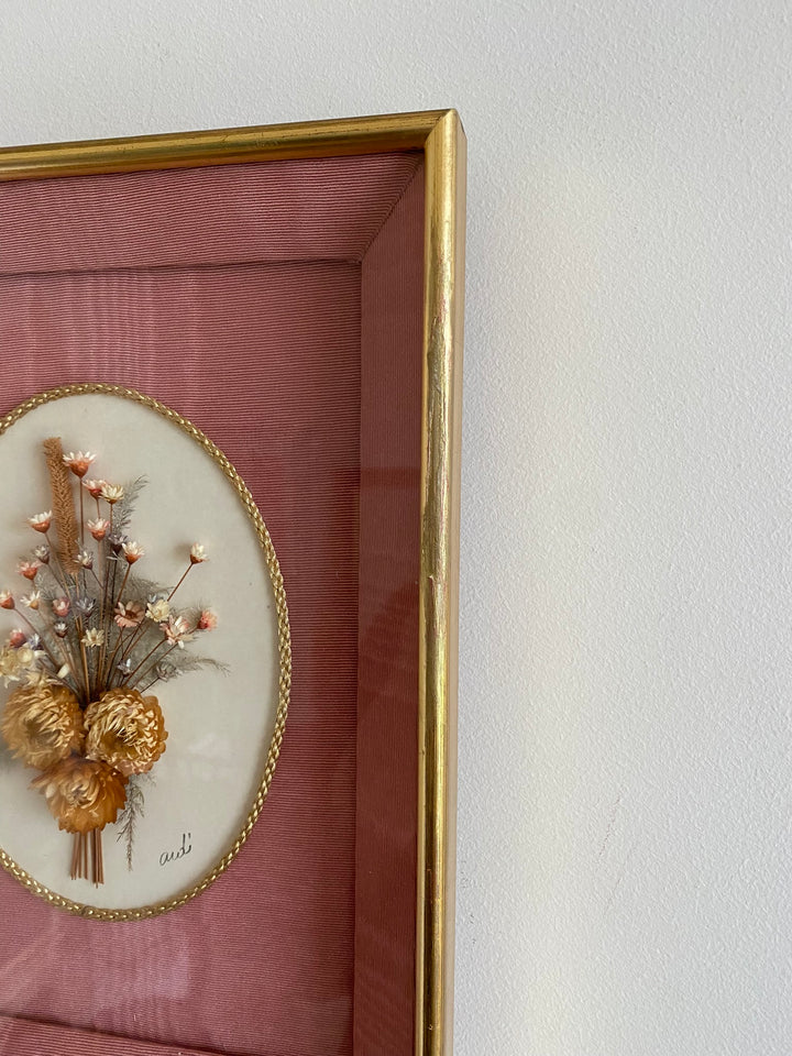 Fleurs séchées encadrées sur fond rose en tissu