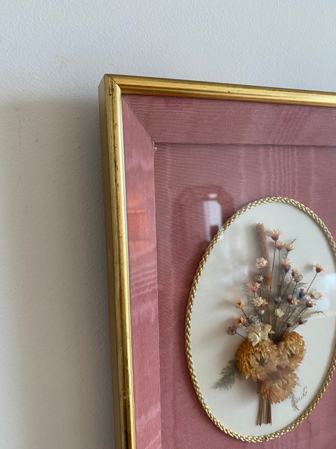 Fleurs séchées encadrées sur fond rose en tissu