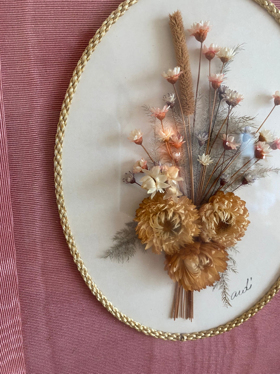Fleurs séchées encadrées sur fond rose en tissu