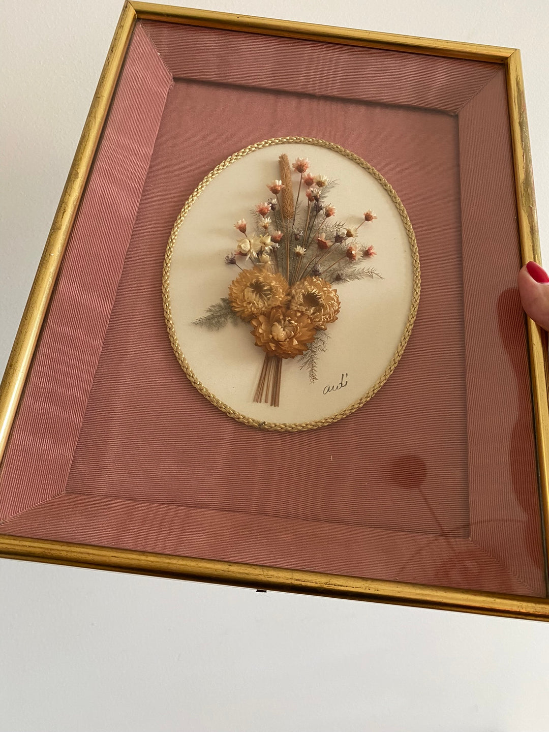Fleurs séchées encadrées sur fond rose en tissu