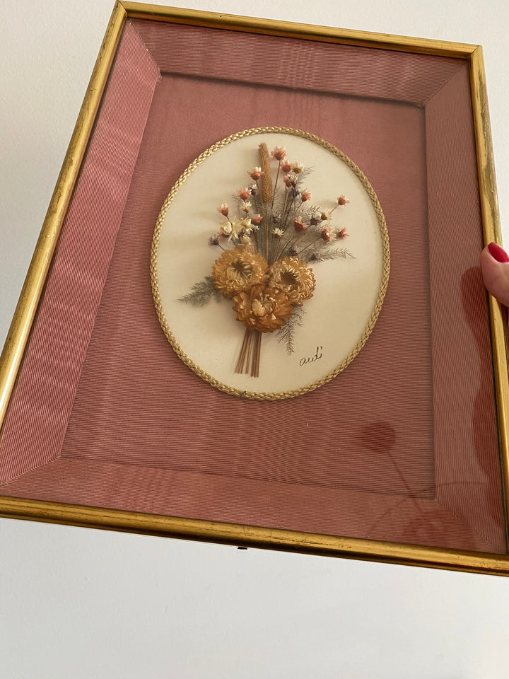 Fleurs séchées encadrées sur fond rose en tissu