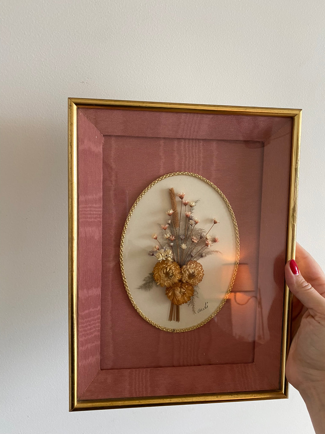 Fleurs séchées encadrées sur fond rose en tissu