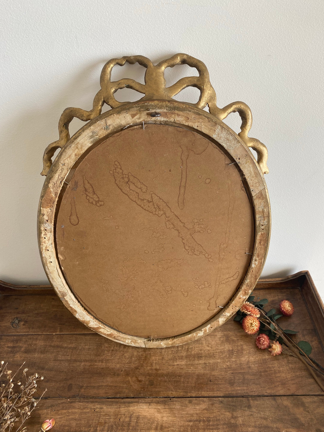 Miroir ovale en bois doré fronton noeud style Louis XVI