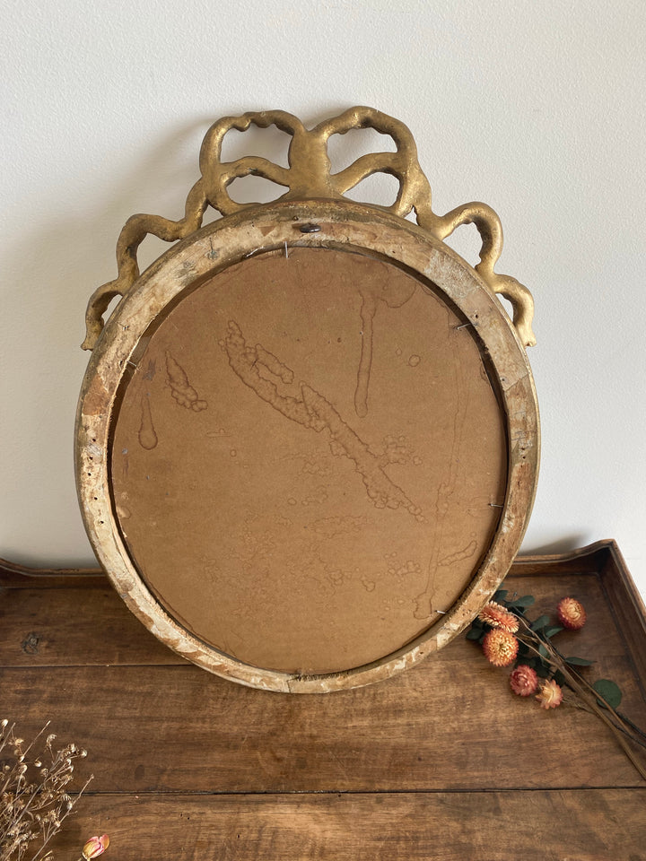 Miroir ovale en bois doré fronton noeud style Louis XVI