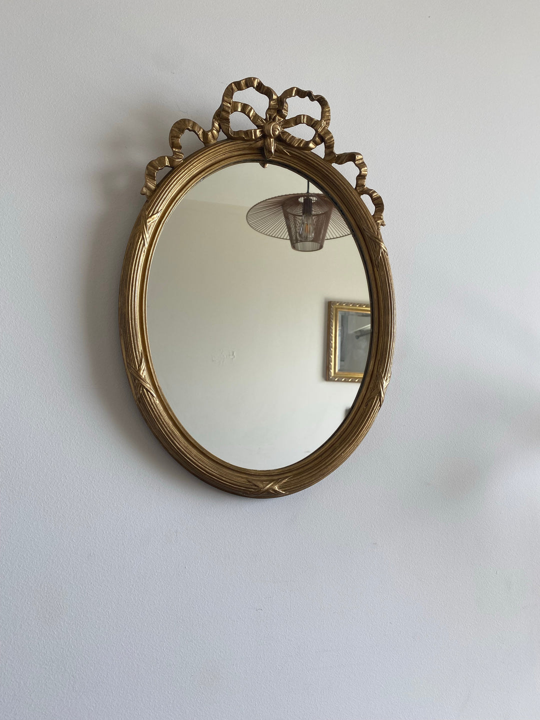 Miroir ovale en bois doré fronton noeud style Louis XVI
