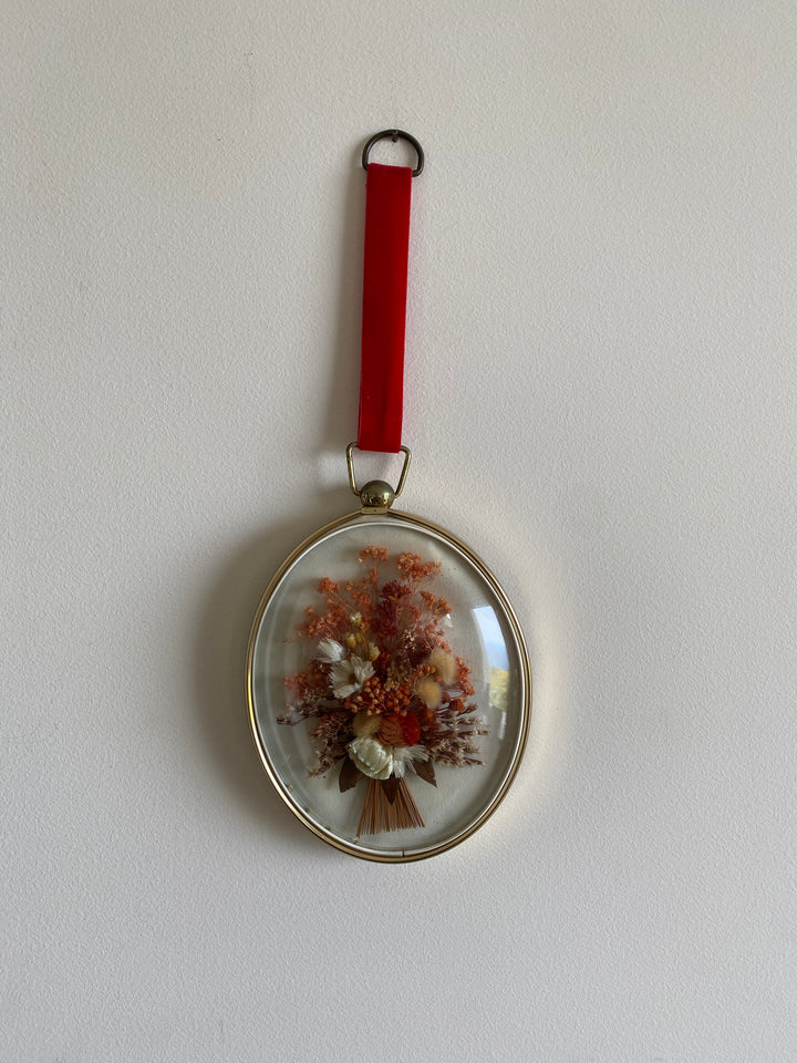 Fleurs séchées roses dans cadre bombé