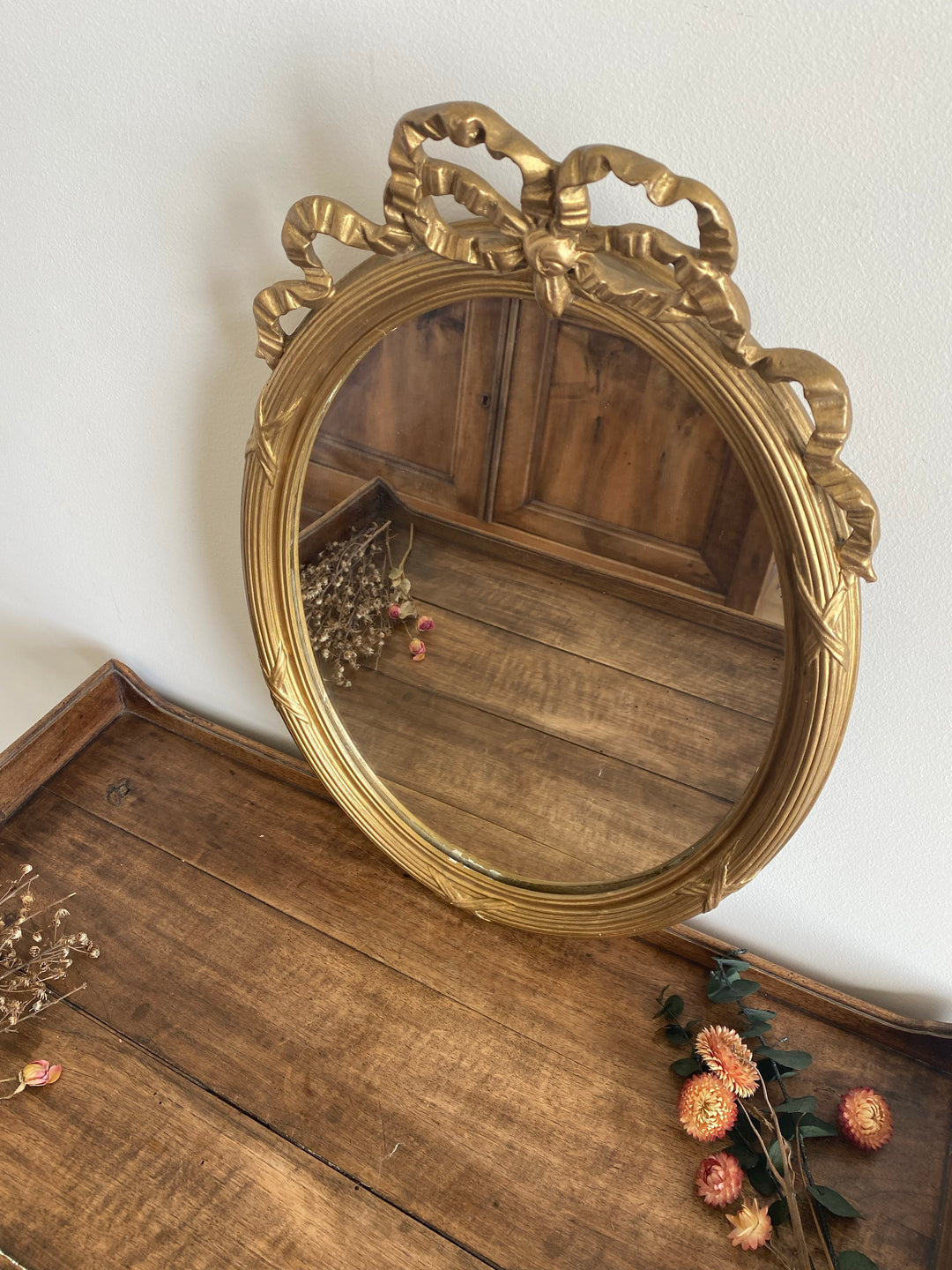 Miroir ovale en bois doré fronton noeud style Louis XVI