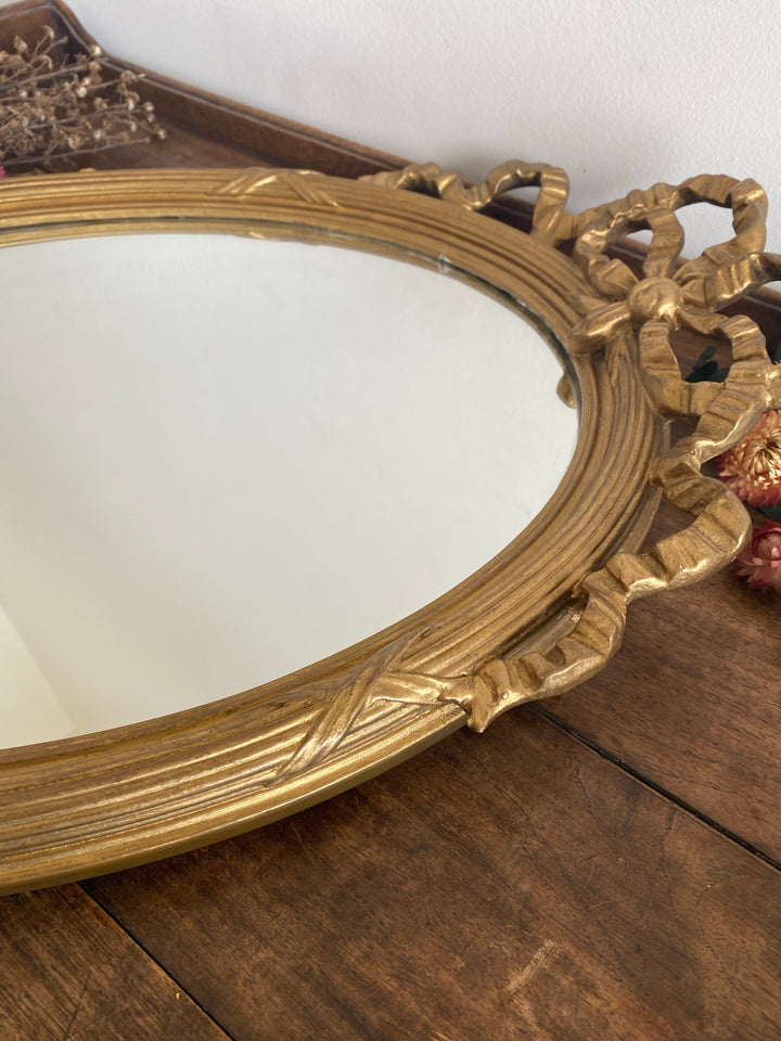 Miroir ovale en bois doré fronton noeud style Louis XVI