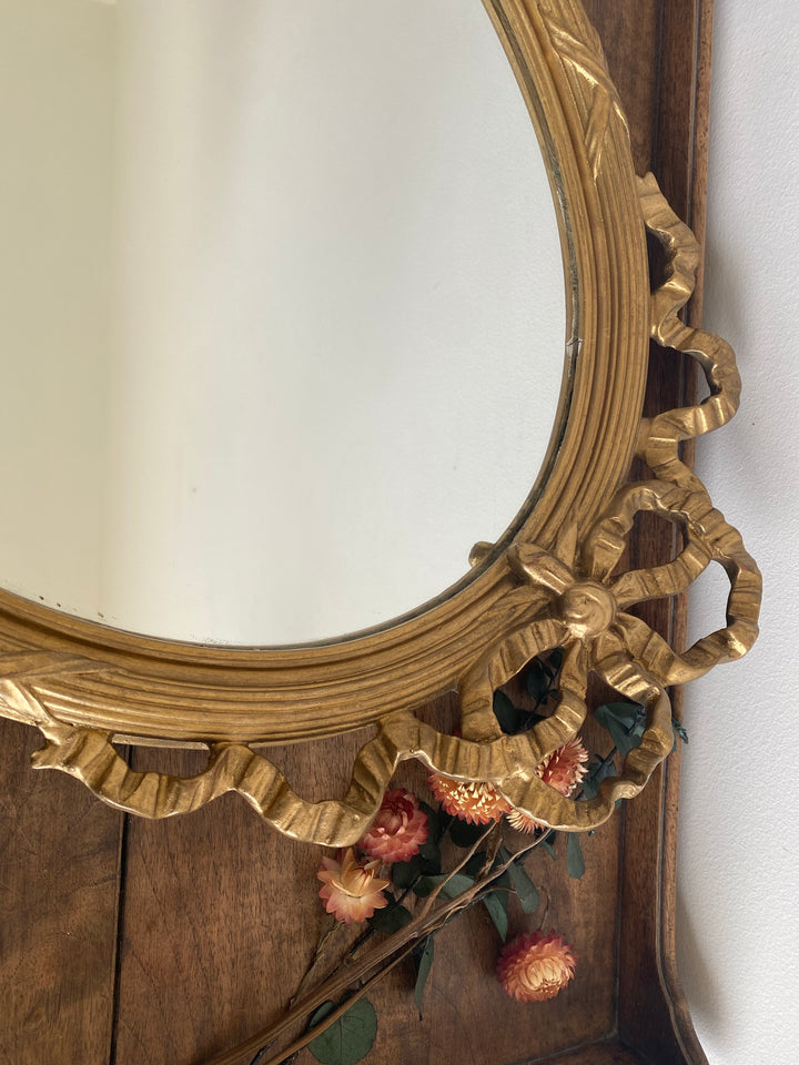 Miroir ovale en bois doré fronton noeud style Louis XVI