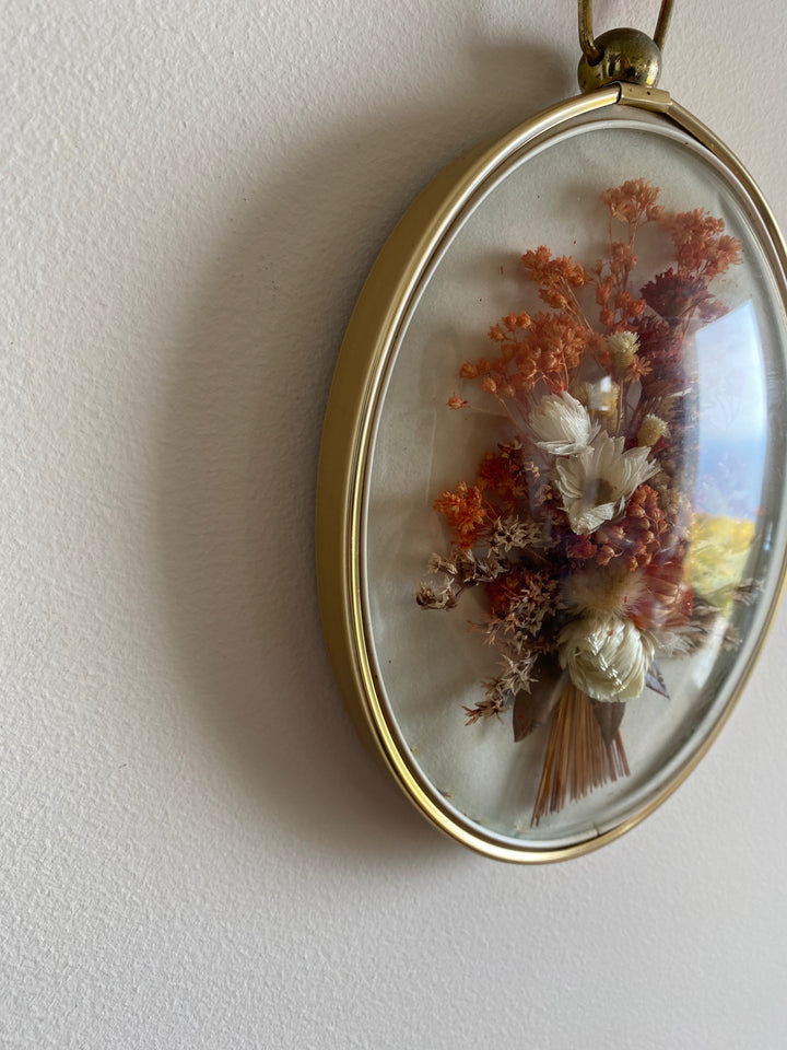 Fleurs séchées roses dans cadre bombé