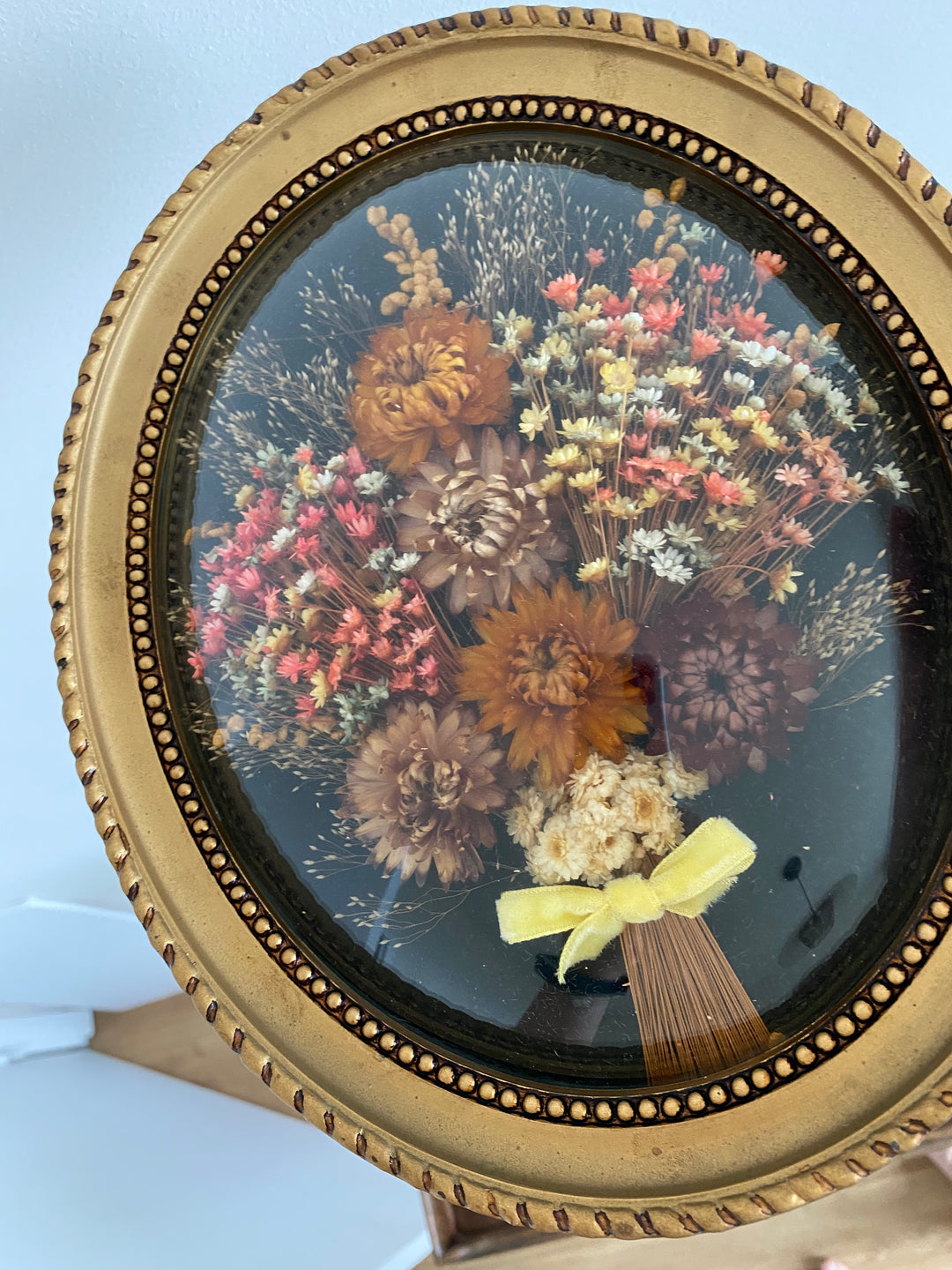 Fleurs séchées encadrée sur fond noir et verre bombé