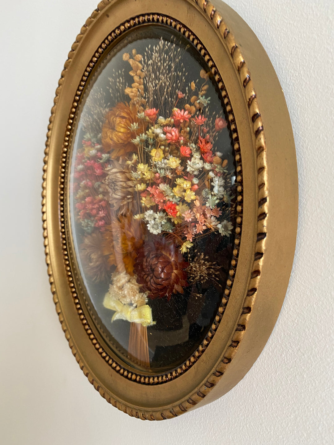 Fleurs séchées encadrée sur fond noir et verre bombé