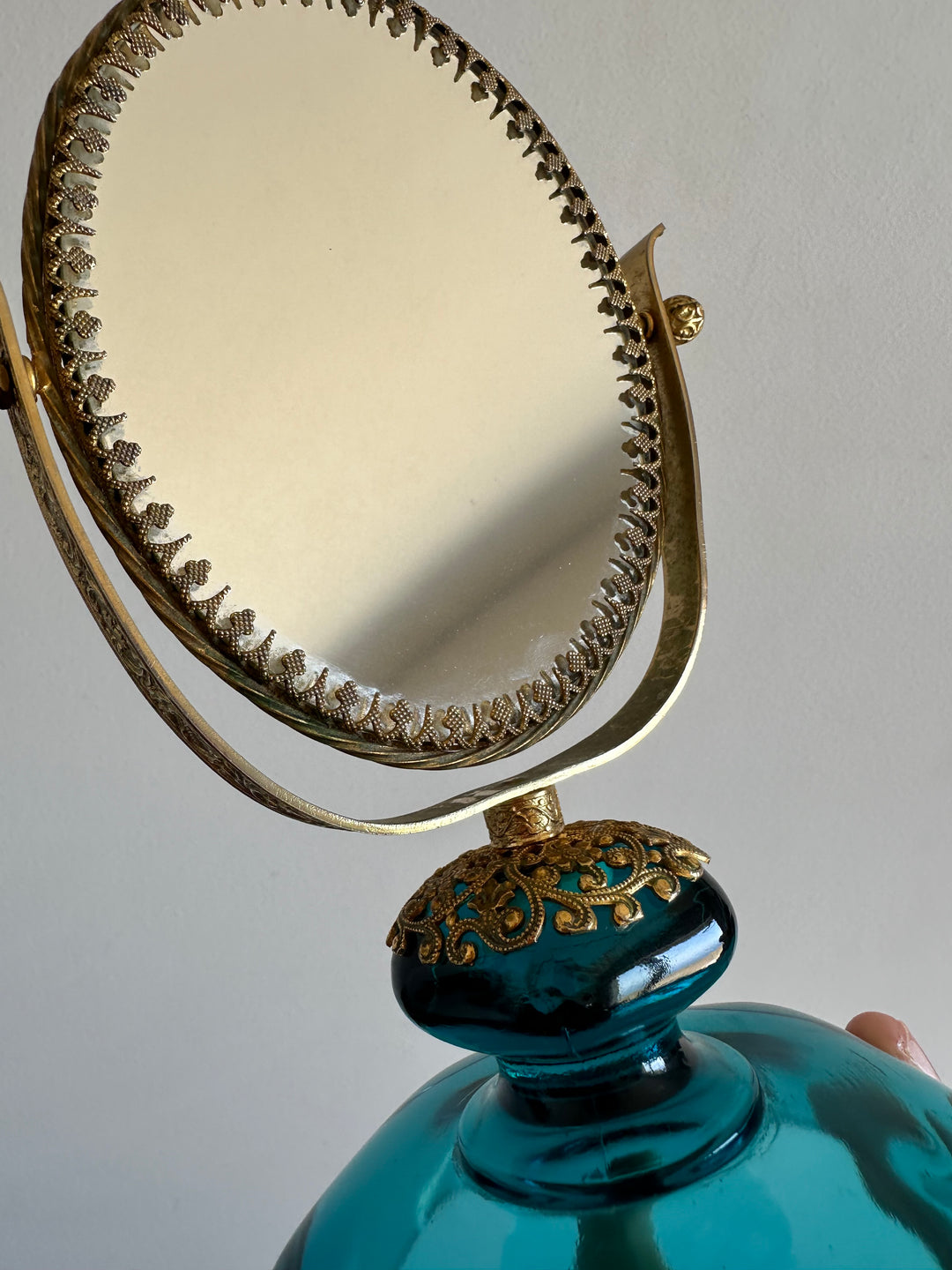 Miroir à poser en laiton dentelé sur socle en verre bleu