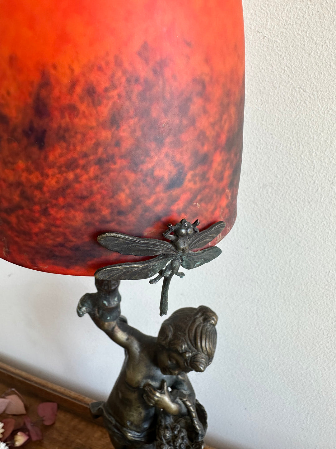 Lampe en bronze fillette au panier globe en verre rouge