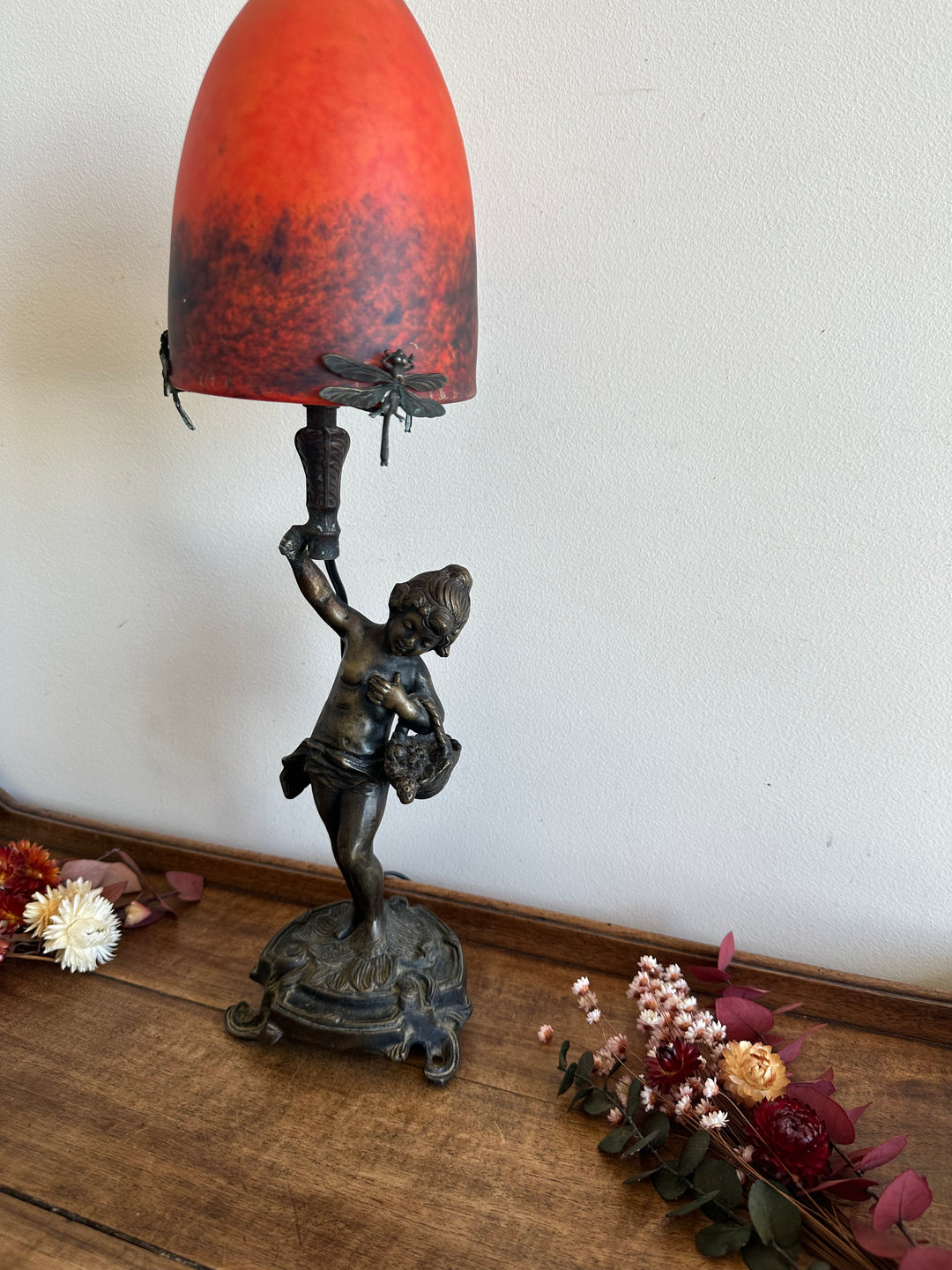 Lampe en bronze fillette au panier globe en verre rouge