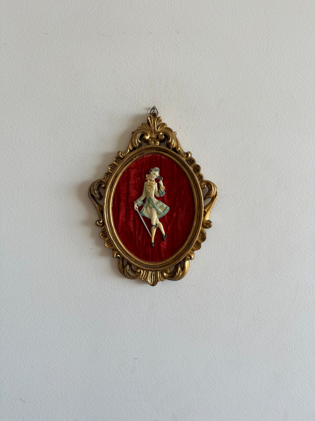 Figurine sur fond de velours rouge encadrement rococo doré