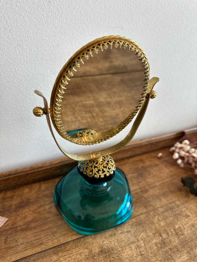 Miroir à poser en laiton dentelé sur socle en verre bleu